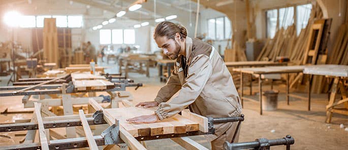A carpenter in  workshop, resizing some wood