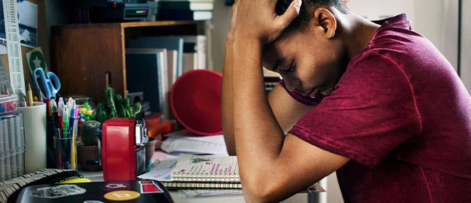 A child revising for an exam experiencing exam stress