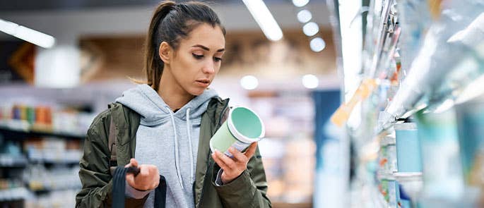 Customer reading healthwashing terms in a supermarket