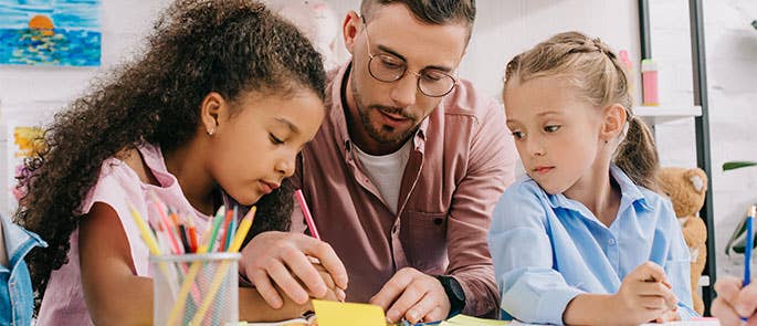 teaching assistant teaching two students in a lesson