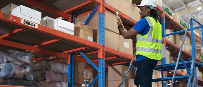 Employee working on a ladder in a warehouse